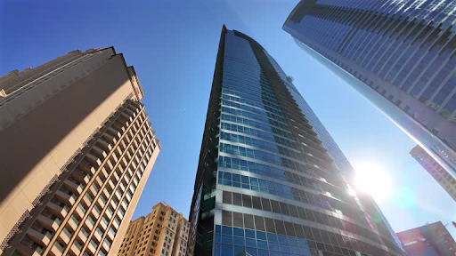 Tall, modern skyscrapers against a clear blue sky showcase the architectural innovation in Damac Hills 2.