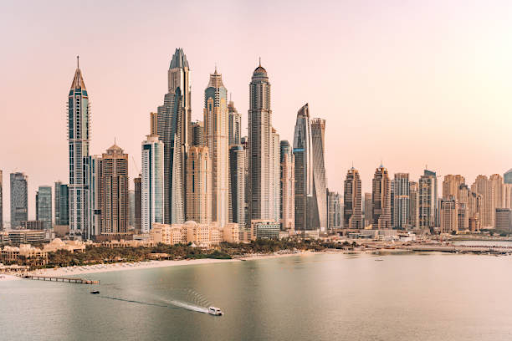 Skyline of modern high-rise buildings and skyscrapers along the coast in Damac Hills 2 at sunset.